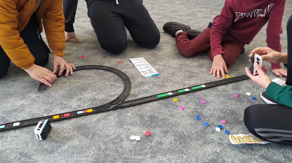 Photographie d'enfants construisant un circuit avec les rails du Smart Train.